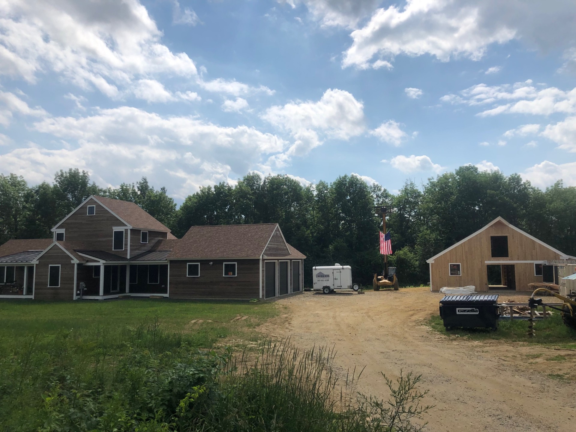 Property view with farmhouse and stable under construction