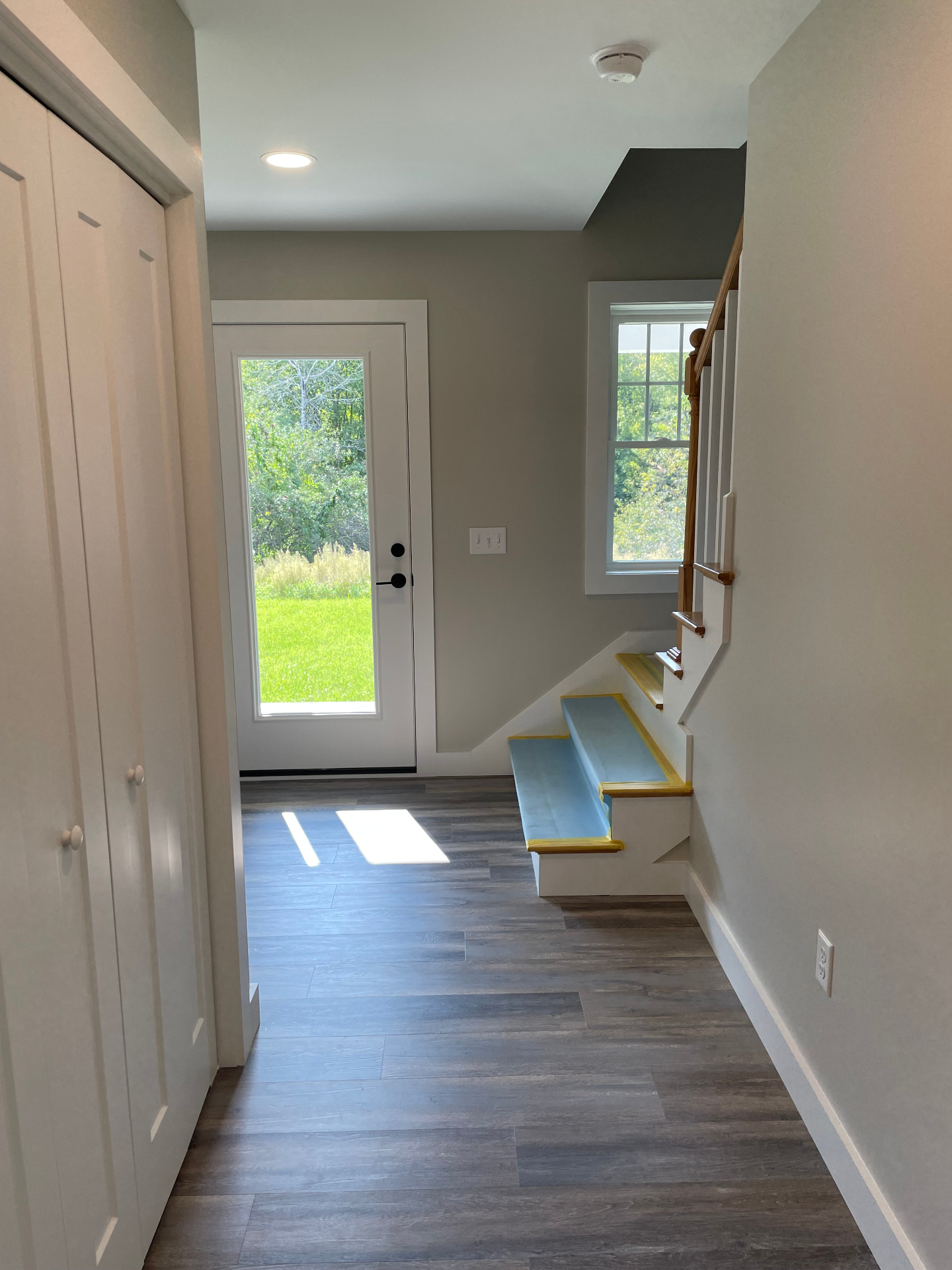 Entry hallway with glass door and staircase