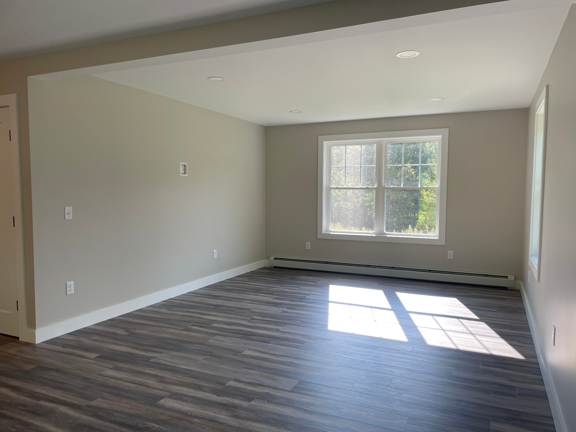 Open living area with large windows and LVP flooring