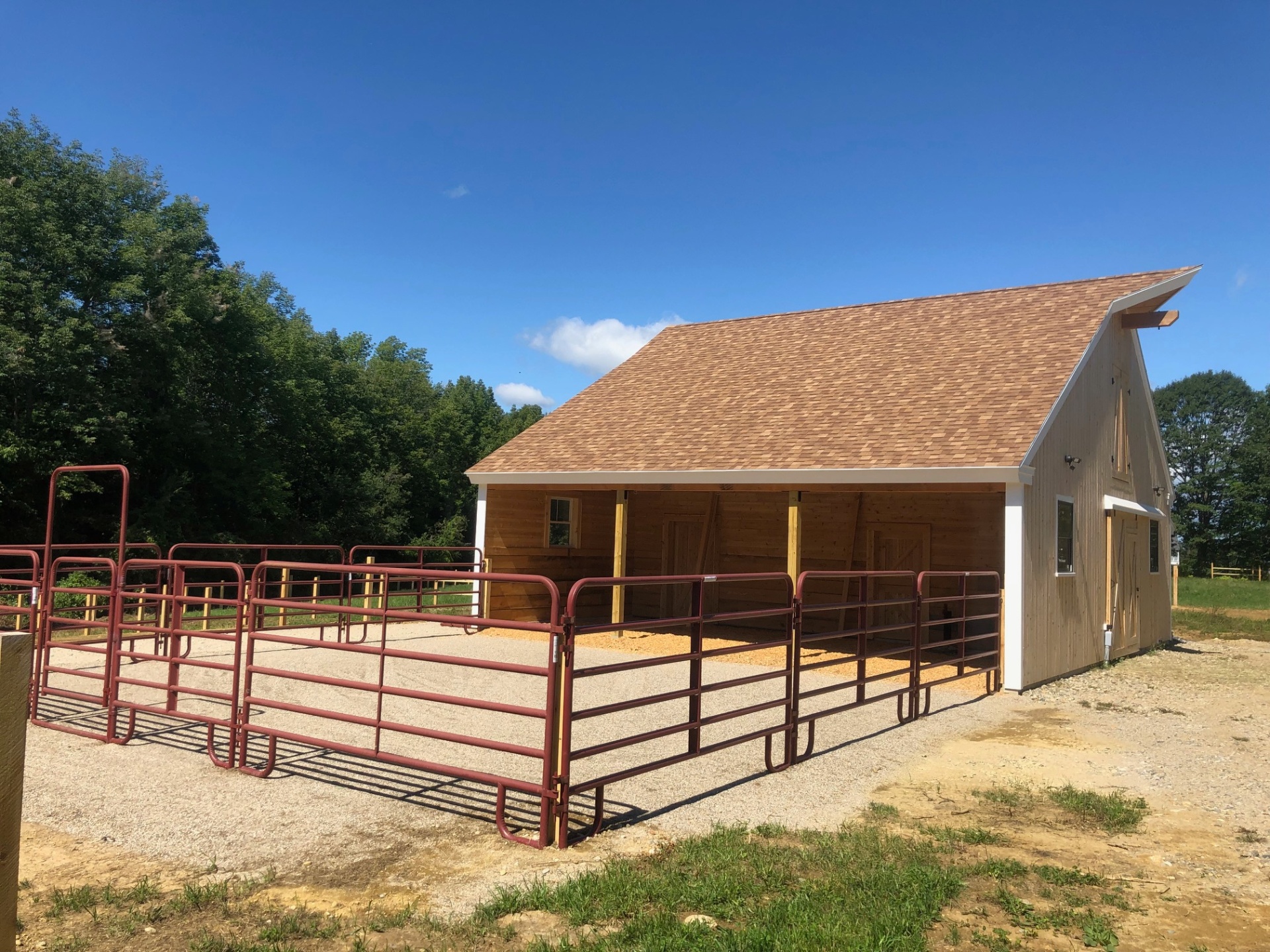 Stable side view with red paddock gates