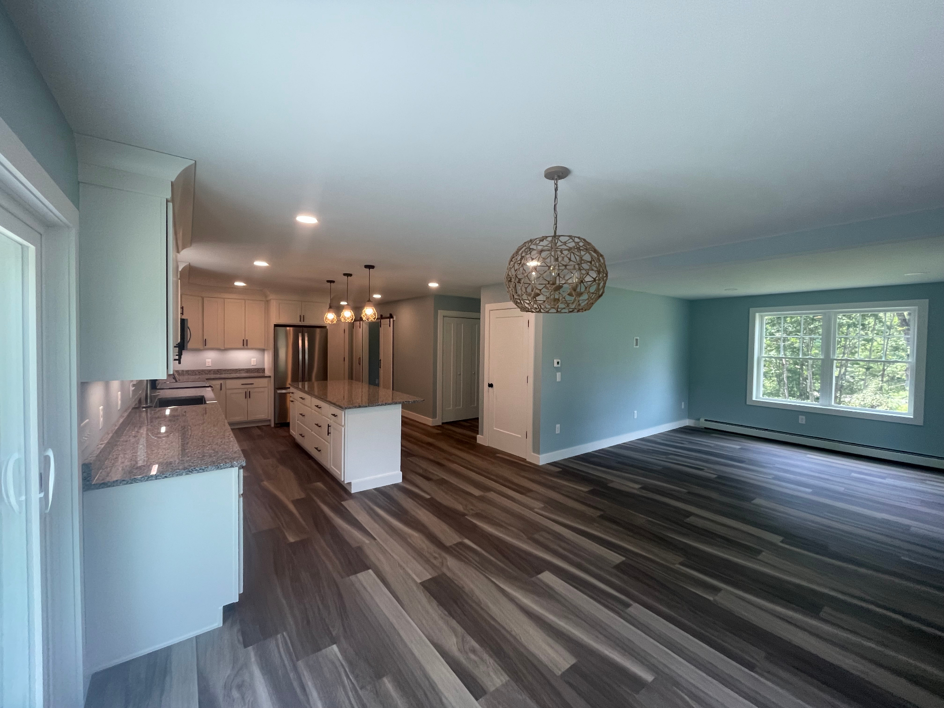 Open-concept kitchen and dining area with granite island, Shaker cabinets, and stainless appliances