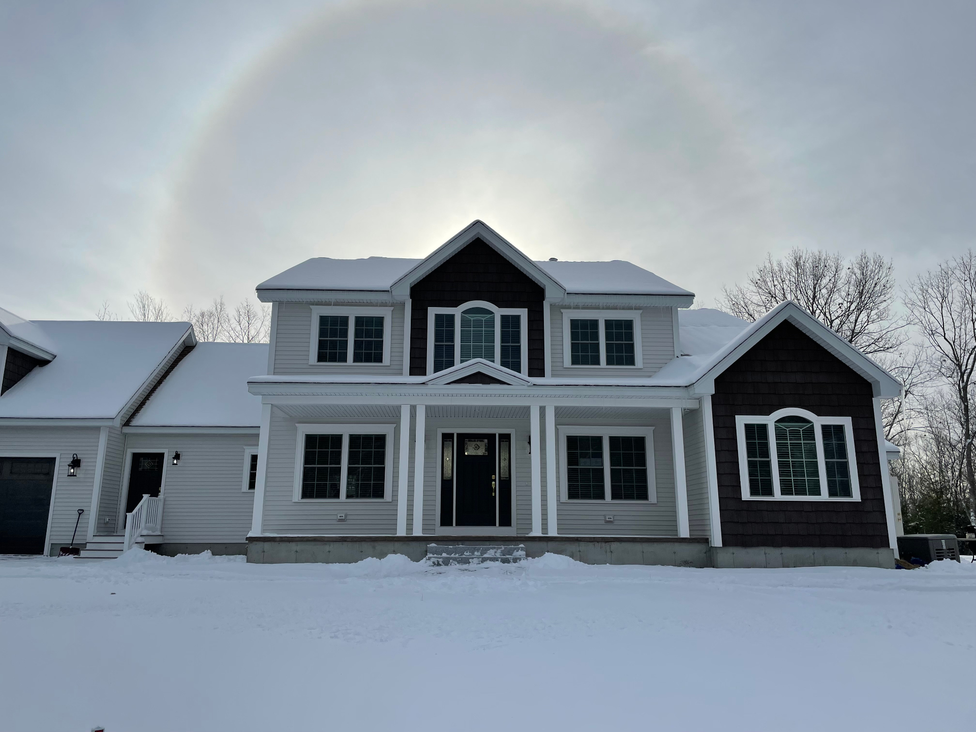 Front elevation of the finished home with shake gables and covered porch