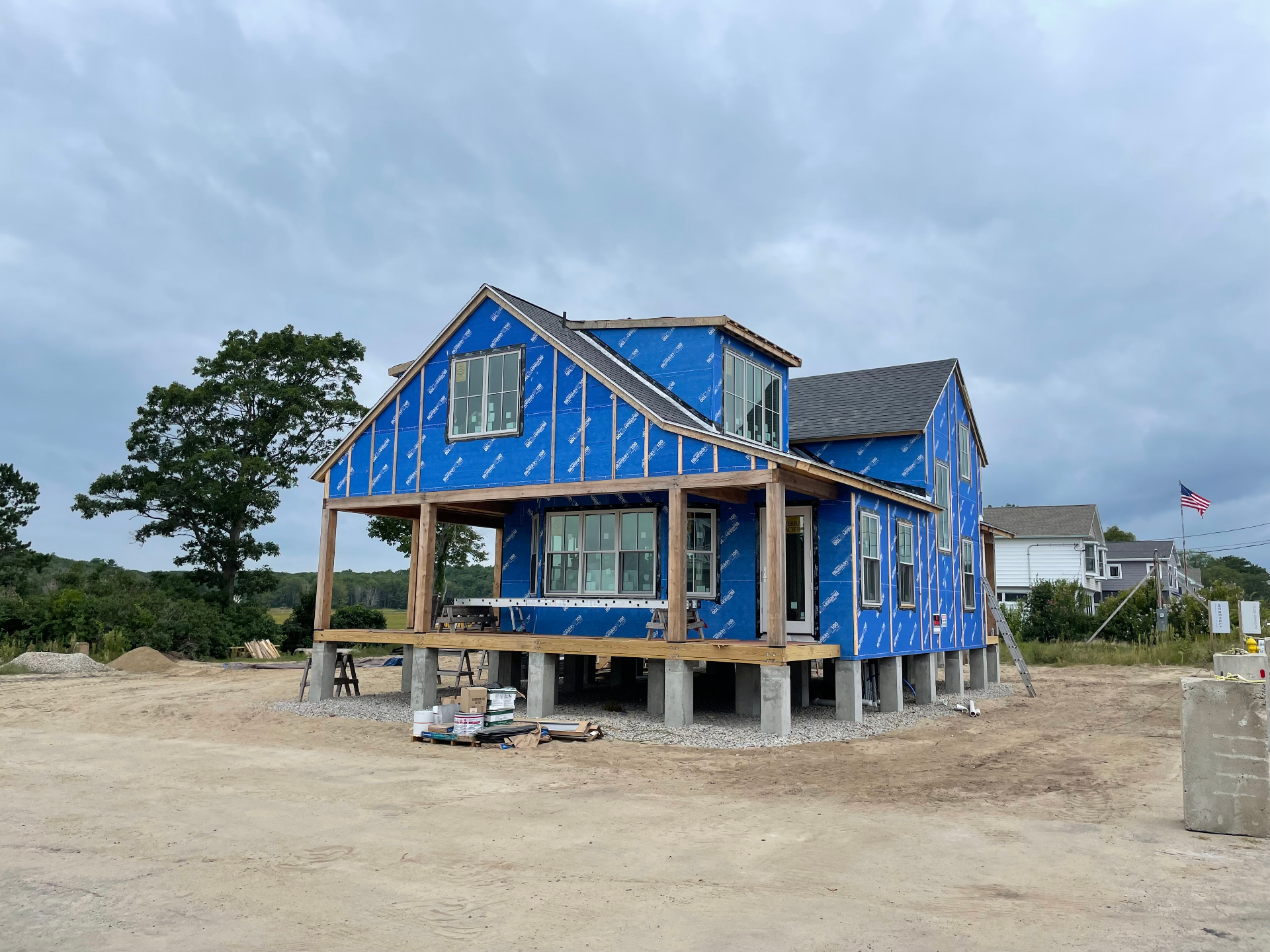 Front elevation of the Biddeford Pool custom home with wrap-around porch on stilts
