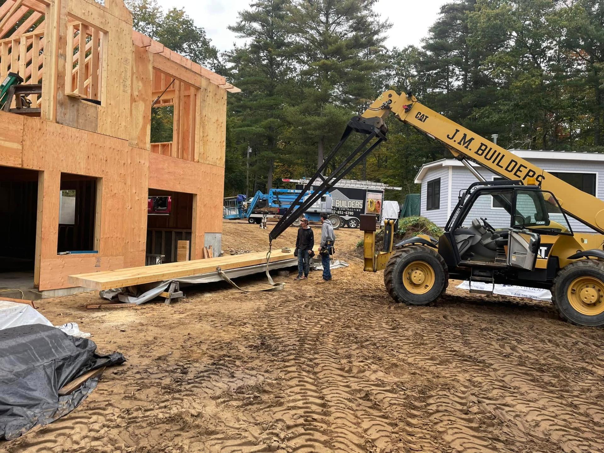 J.M. Builders crew on a Maine jobsite with branded equipment