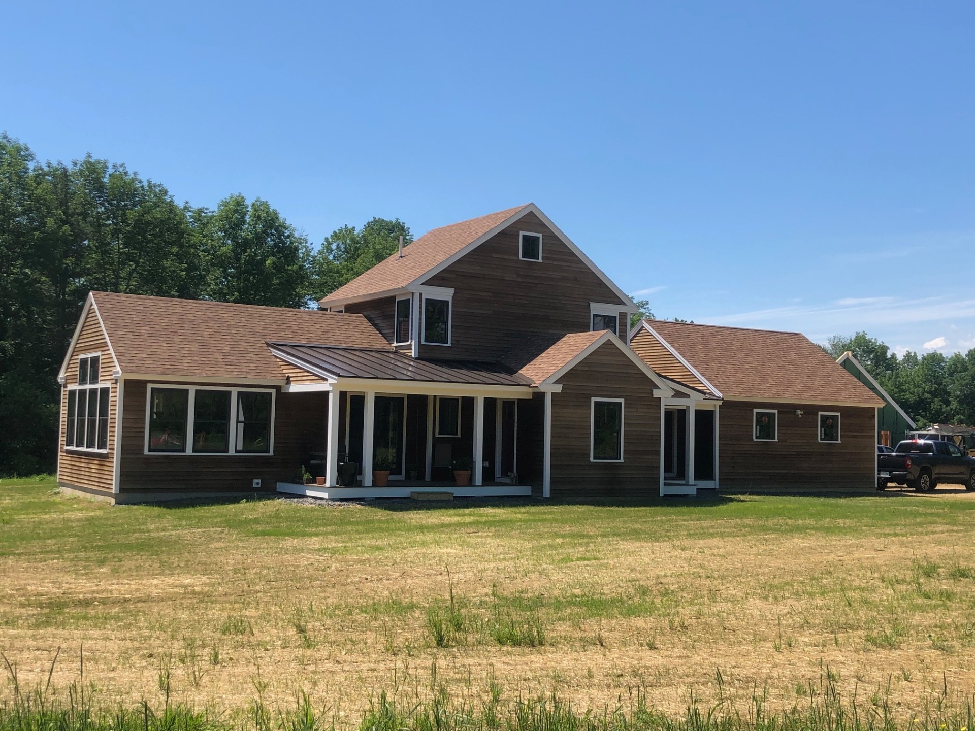 Side angle of completed farmhouse with metal roof accents